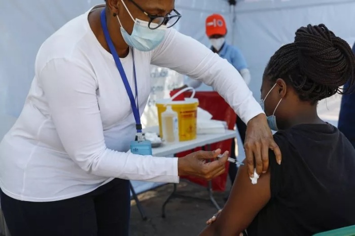 أخصائية رعاية صحية يعطي لقاح جونسون لامرأة خارج مركز اقتراع في بريتوريا يوم 1 نوفمبر 2021، خلال الانتخابات المحلية في جنوب إفريقيا