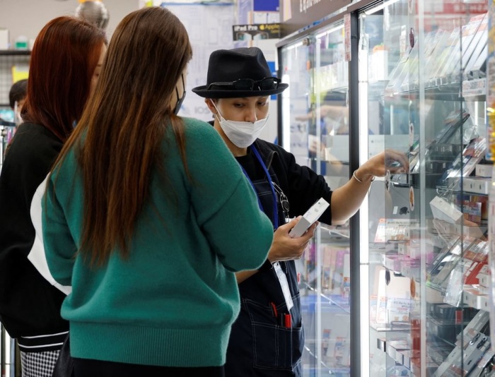 بائعة تعرض جهاز أيفون مستعمل لعملاء من تايلاند في متجر Iosys Corp لبيع الموبيلات المستعملة في منطقة أكيهابارا للإلكترونيات في طوكيو، اليابان، 28 أكتوبر 2022